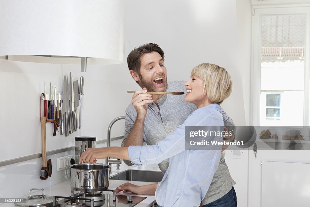 Germany, Bavaria, Munich, Mature woman cooking food while man feeding