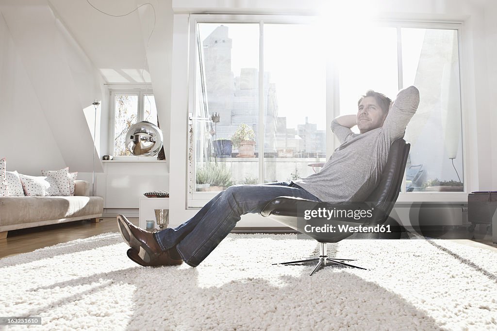 Germany, Bavaria, Munich, Man sitting on armchair