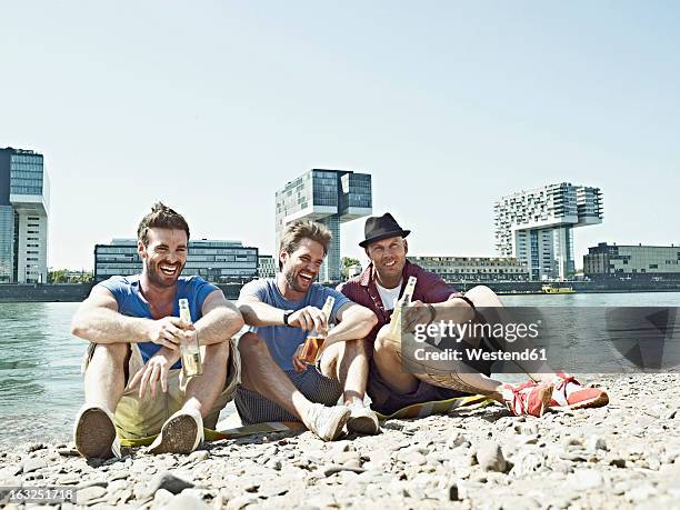 germany, cologne, young men drinking beer - colonia renania fotografías e imágenes de stock