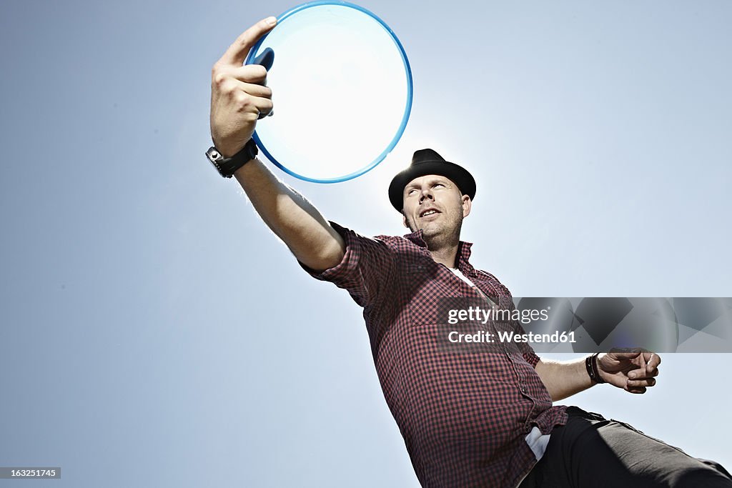 Germany, Cologne, Mature man playing flying disc