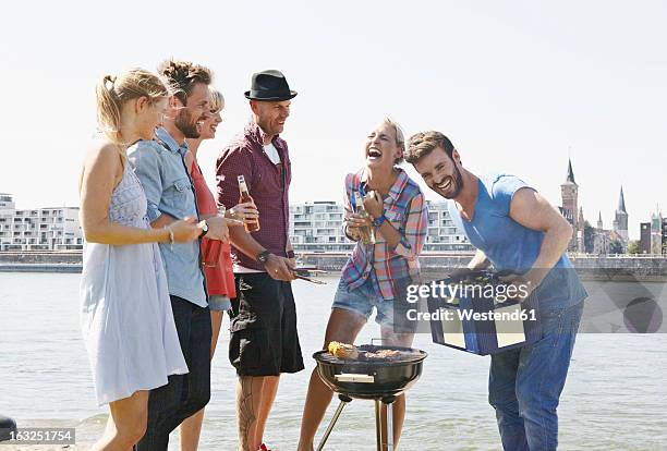 germany, cologne, group of people gathered around barbecue - holzkiste stock-fotos und bilder