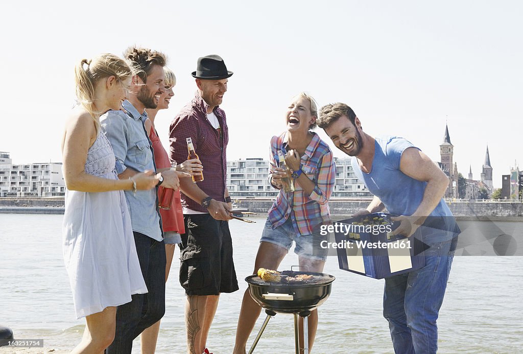 Germany, Cologne, Group of people gathered around barbecue