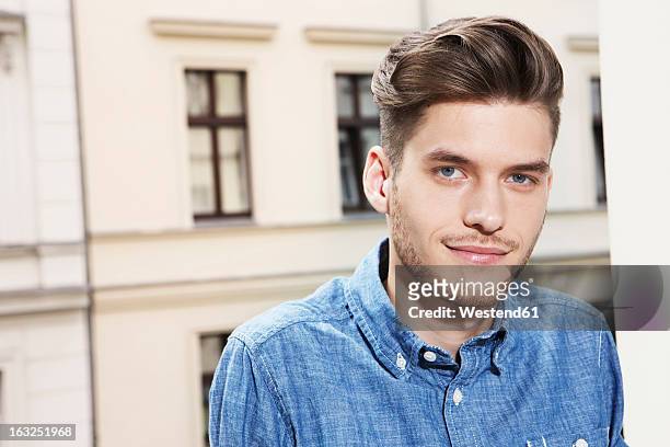 germany, berlin, young man smiling, portrait - blue eye stock-fotos und bilder