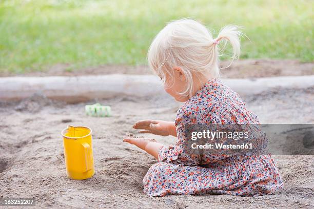 germany, girl playing with sand on playground - 2 girls 1 sandbox stock pictures, royalty-free photos & images