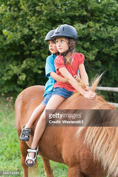 germany, munich, girls learning to ride horse in children's camp - riding hat fotografías e imágenes de stock
