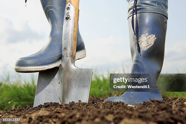 germany, bavaria, human legs with spade on field - spade fotografías e imágenes de stock