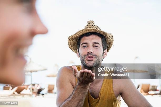 spain, mid adult man blowing kiss to woman - blowing a kiss stockfoto's en -beelden