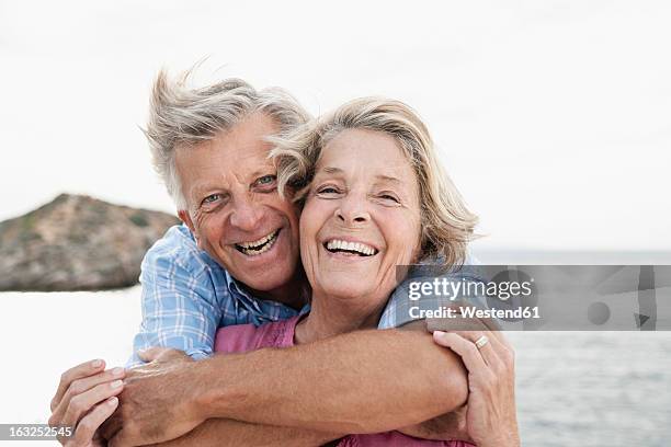 spain, senior couple embracing at harbour, smiling - senior couple smiling stock pictures, royalty-free photos & images