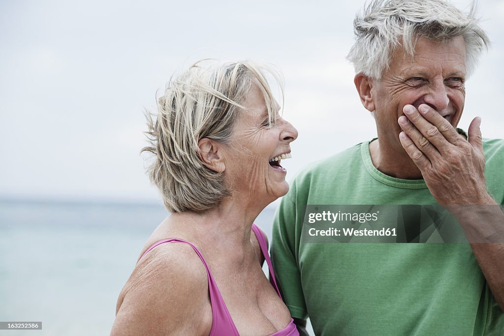 Spain, Senior couple smiling on beach
