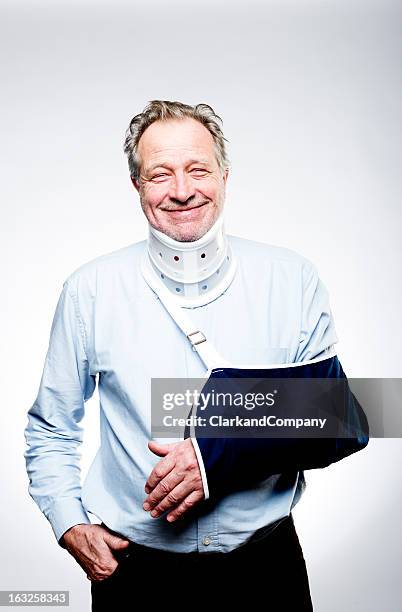 senior man suffering from whiplash with neck brace and sling - man neck brace stock pictures, royalty-free photos & images