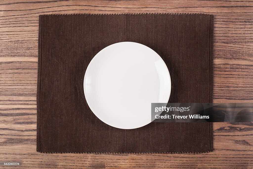 An empty plate on a wooden table