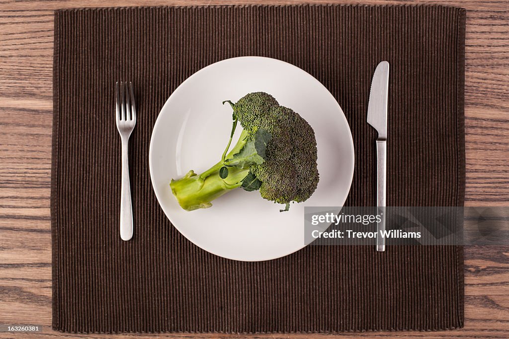 A whole head of broccoli on a plate