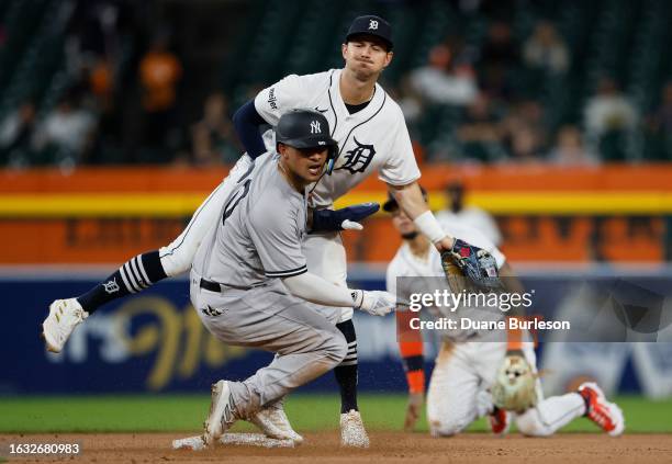 Second baseman Zach McKinstry of the Detroit Tigers lands on Everson Pereira of the New York Yankees after turning the ball for a double play during...