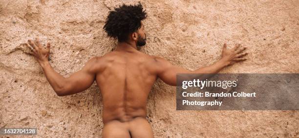 fine art nude man in nature connecting with stone wall - fault sports stock pictures, royalty-free photos & images