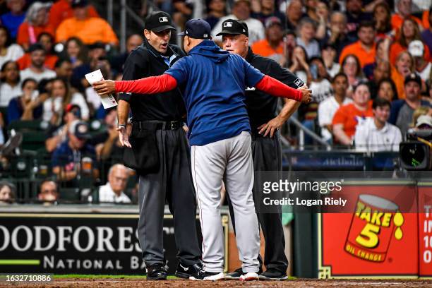 Manager Alex Cora of the Boston Red Sox exchanges words with umpire Pat Hoberg in the seventh inning against the Houston Astros at Minute Maid Park...