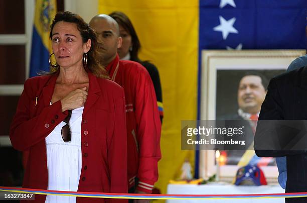 Woman cries as she stands with other mourners during a ceremony commemorating the death of Venezuelan President Hugo Chavez in the Venezuelan Embassy...