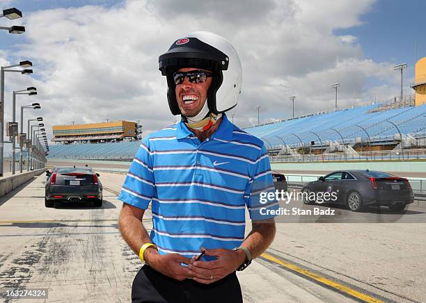 Golpher Charl Schwartzel of South Africa smiles after racing around the Homestead-Miami Speedway as part of The Cadillac Driving Experience event...