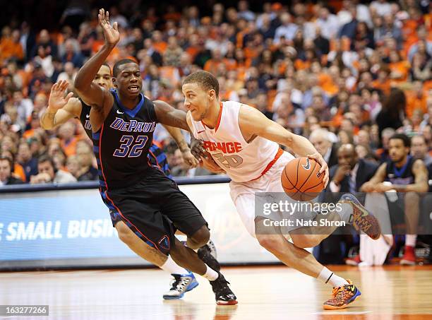 Brandon Triche of the Syracuse Orange drives to the basket against Charles McKinney of the DePaul Blue Demons during the game at the Carrier Dome on...