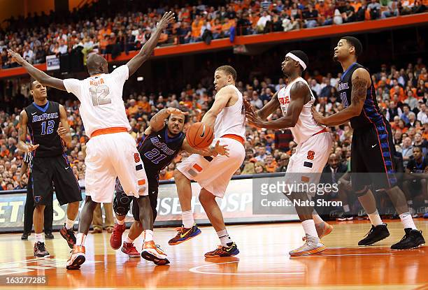 James Crockett of the DePaul Blue Demons loses the ball driving to the basket against Brandon Triche, Baye Moussa-Keita and C.J. Fair of the Syracuse...