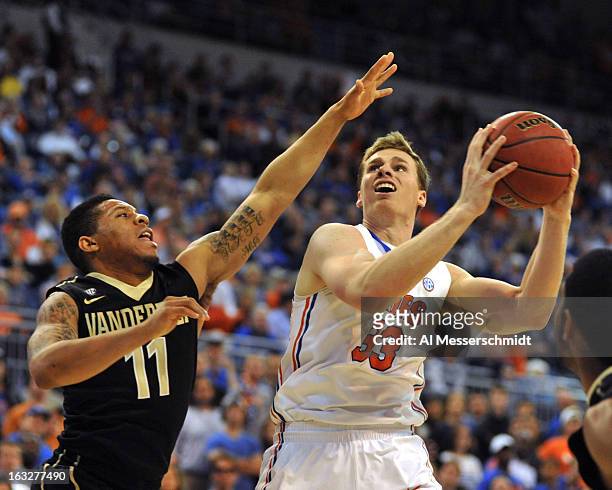 Forward Erik Murphy of the Florida Gators drives against guard Kyle Fuller of the Vanderbilt Commodores March 6, 2013 at Stephen C. O'Connell Center...
