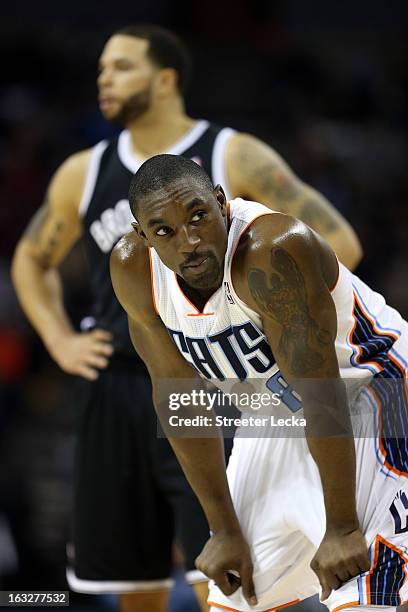 Ben Gordon of the Charlotte Bobcats looks at the crowd as Deron Williams of the Brooklyn Nets stands in the background during their game at Time...