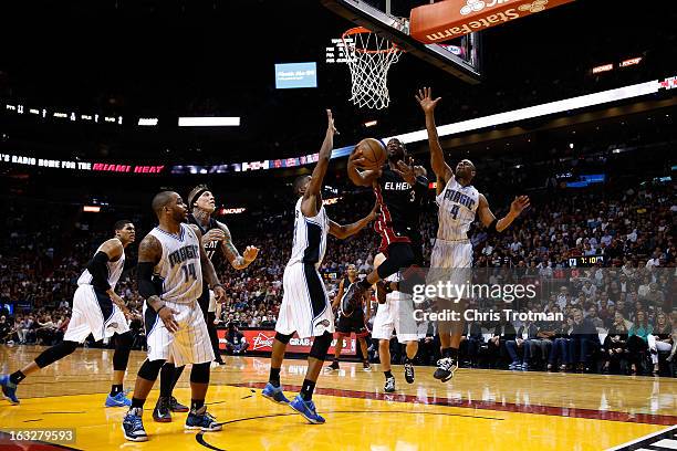 Dwyane Wade of the Miami Heat drives to the basket past Moe Harkless and Arron Afflalo of the Orlando Magic at American Airlines Arena on March 6,...