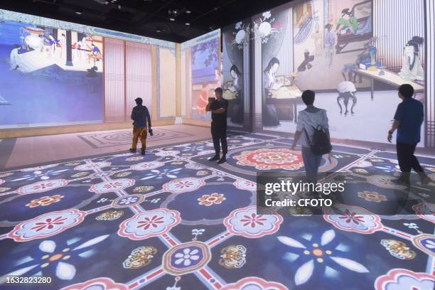 Visitors enjoy an immersive look at "digital ancient paintings" in the digital exhibition hall of the new Zhejiang Museum in Hangzhou, Zhejiang...