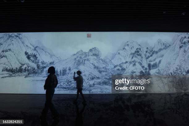 Visitors enjoy an immersive look at "digital ancient paintings" in the digital exhibition hall of the new Zhejiang Museum in Hangzhou, Zhejiang...