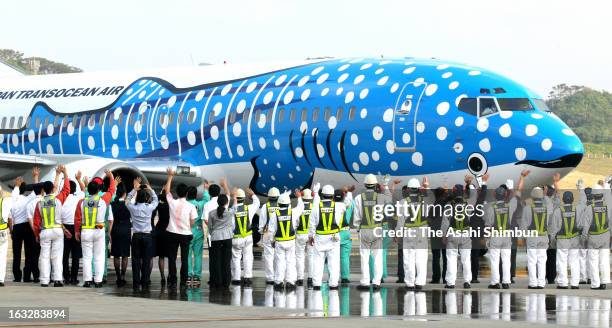 Japan Transocean Air staffs see off the first flight to Naha, which whale shark is drawn on the aircraft, at New Ishigaki Airport on March 7, 2013 in...