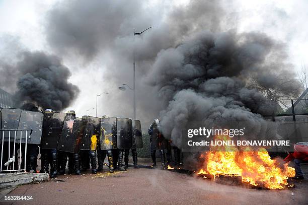 Protesting Goodyear France workers face riot police in front of the French headquarters of the the US tyre and rubber firm in the western Paris...