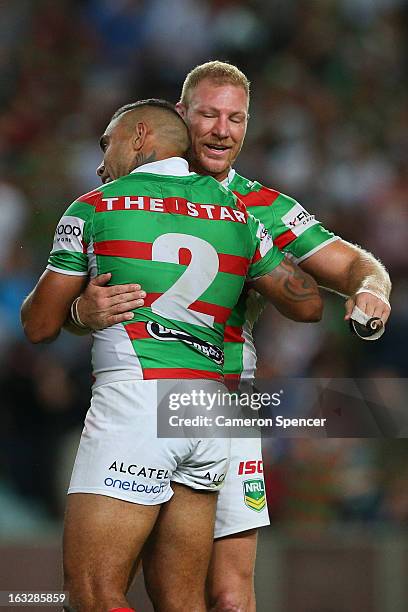 Nathan Merritt and Michael Crocker of the Rabbitohs embrace after winning the round one NRL match between the Sydney Roosters and the South Sydney...