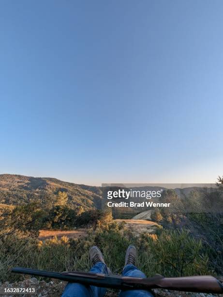 hunter rests with shotgun over california valley wilderness - valley guns stock pictures, royalty-free photos & images