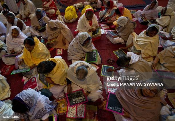 Elderly Indian widows attend a reading and writing class at the Mahila Ashram, a shelter home for widows in Vrindavan some 150 kms south-east of New...