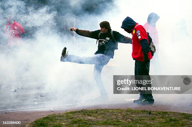 Protesting Goodyear France worker faces riot police in front of the French headquarters of the US tyre and rubber firm in the western Paris suburb of...