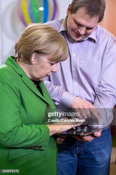 Jens Begemann , general manager of the Wooga company, explains German Chancellor Angela Merkel a game on the tablet computer, during a visit in the...