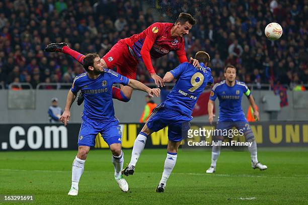 Lukasz Szukata of FC Steaua heads the ball over Branislav Ivanovic of Chelsea and Fernando Torres of Chelsea during the UEFA Europa League Round of...