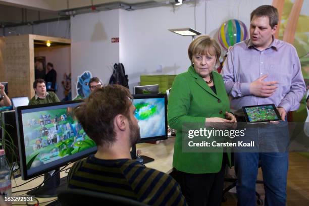 Jens Begemann , general manager of the Wooga company, explains German Chancellor Angela Merkel a game on the tablet computer, during a visit in the...