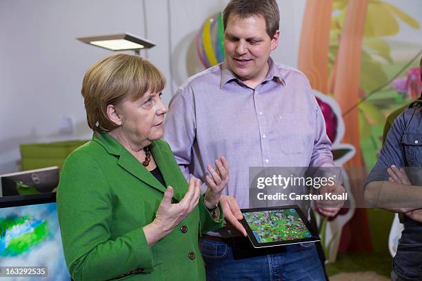 Jens Begemann , general manager of the Wooga company, explains German Chancellor Angela Merkel a game on the tablet computer, during a visit in the...