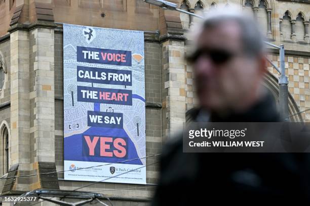 Man walks past a billboard on a side of a church advocating a Yes vote in an upcoming referendum in Melbourne on August 30, 2023. Prime Minister...