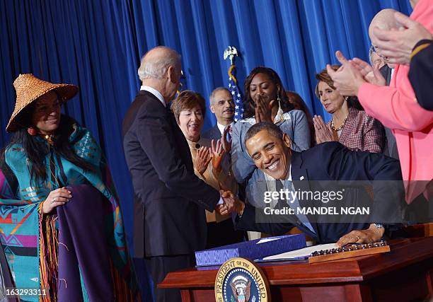 President Barack Obama shakes hands with Vice President Joe Biden after signing the Violence Against Women Act on March 7, 2013 in the Department of...
