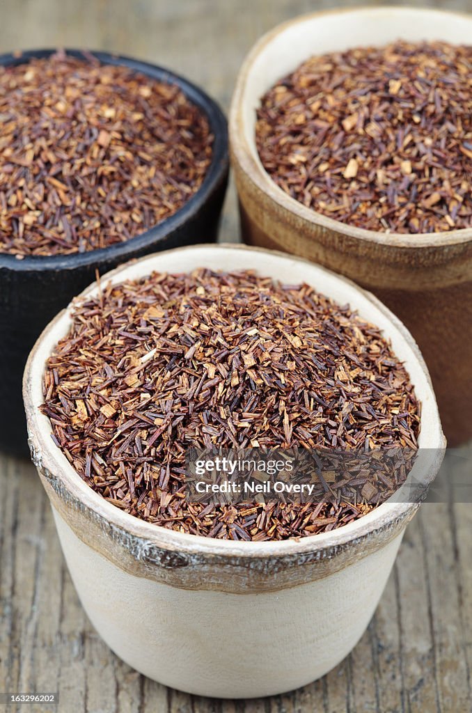 Dried rooibos tea in small wooden pots