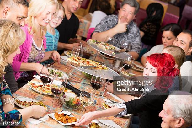 large group of people celebrating at a pizza restaurant - crowded restaurant stock pictures, royalty-free photos & images