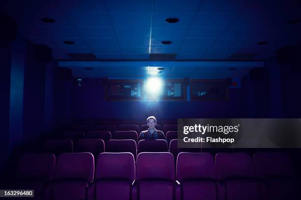 man watching a movie in empty cinema - cinema seats stockfoto's en -beelden