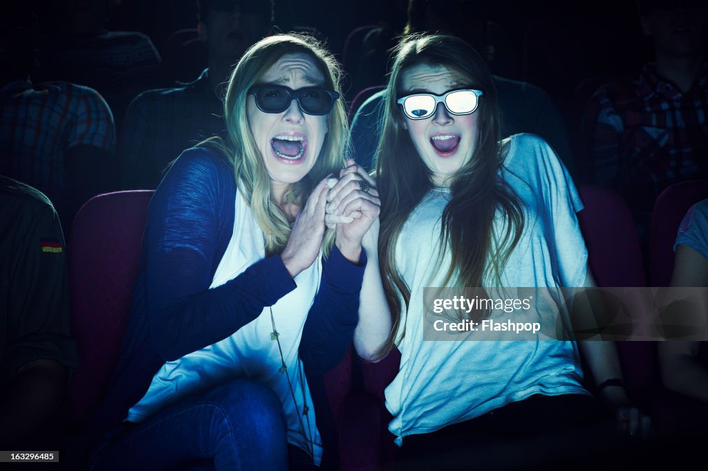 Two girlfriends wearing 3D glasses at the movies