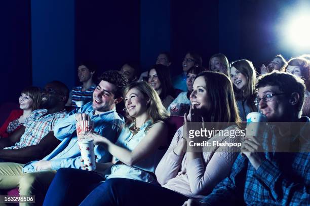 audience enjoying movie at the cinema - filmindustrie stock-fotos und bilder