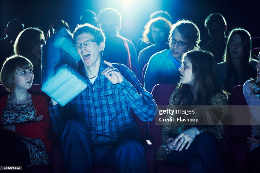 Man using giant phone during movie at cinema