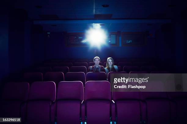 couple watching a movie in an empty cinema - filmindustrie stock-fotos und bilder