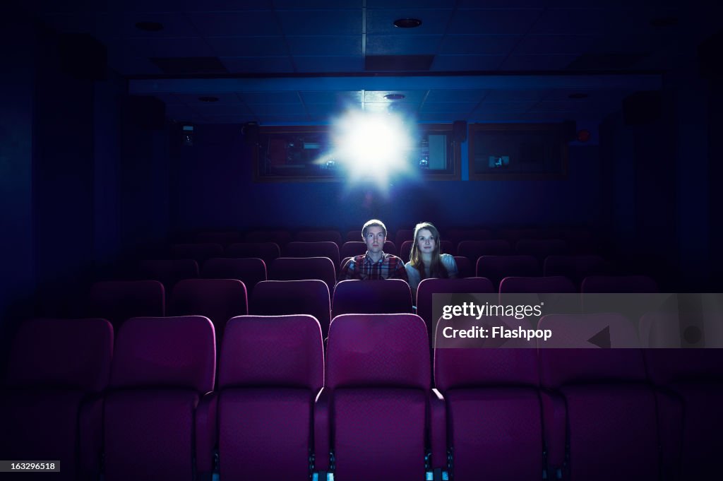 Couple watching a movie in an empty cinema