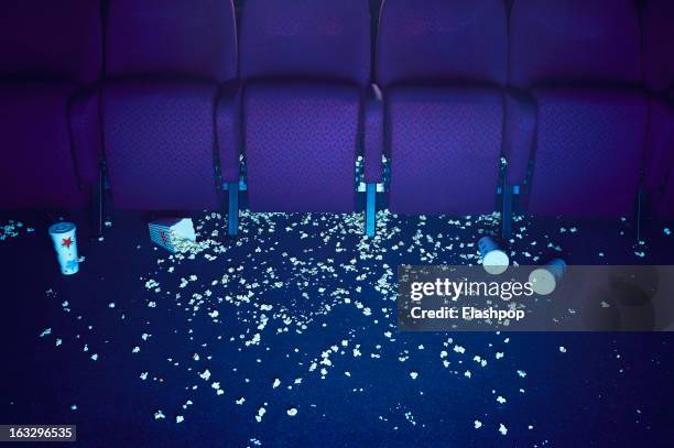 spilt popcorn and empty drinks on floor of cinema - cinema interior stock pictures, royalty-free photos & images