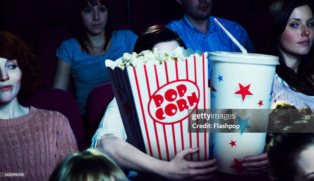 Woman holding giant sized popcorn and drink